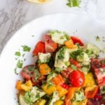 Avocado Bell Pepper Salad sits in a white bowl on a white background. A text overlay gives the name of the salad.