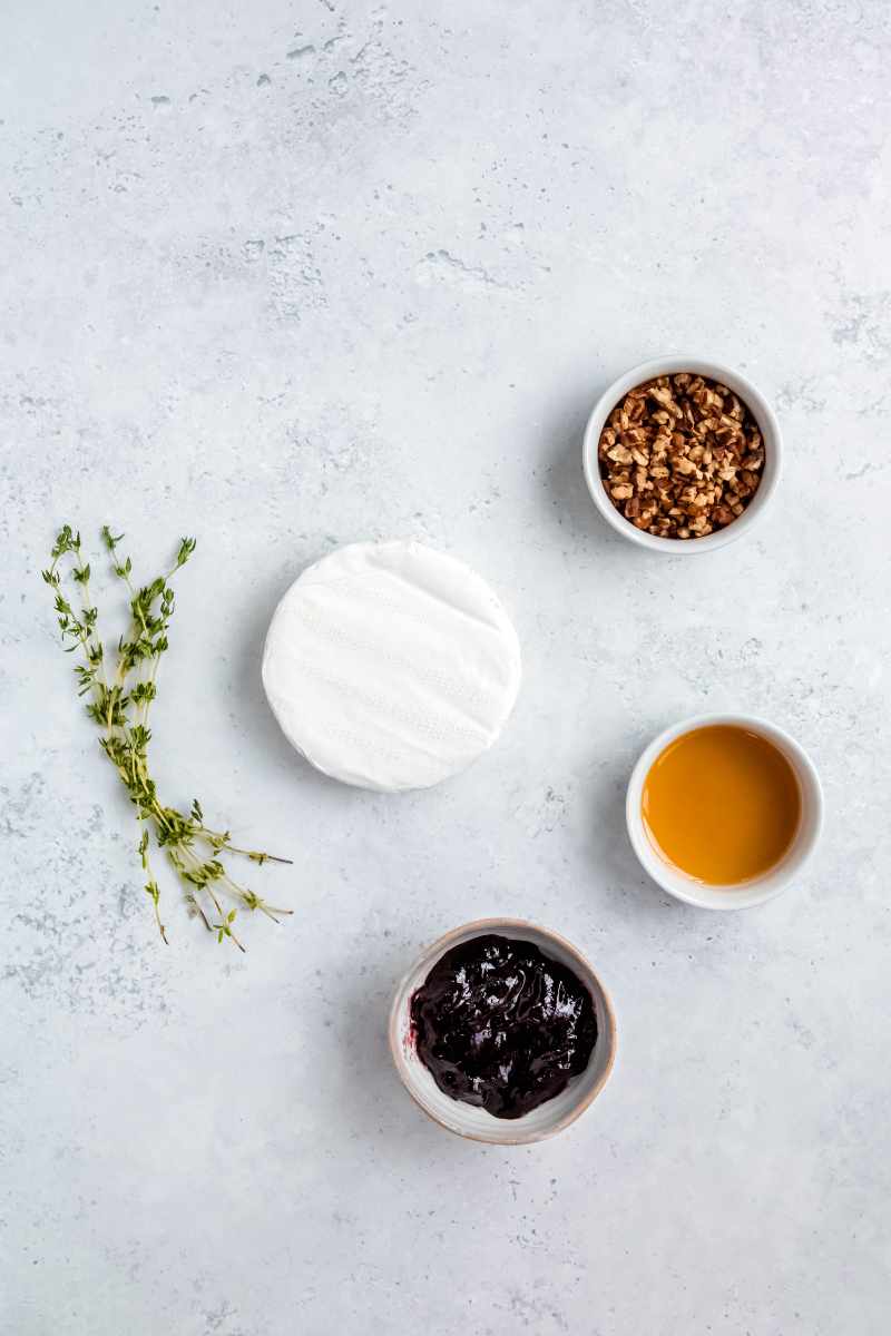 Overhead of all ingredients needed to make baked brie with jam.