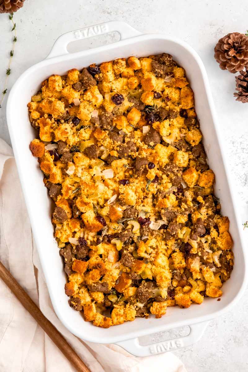 Birdseye view of baked cornbread dressing in a white Staub baking dish.