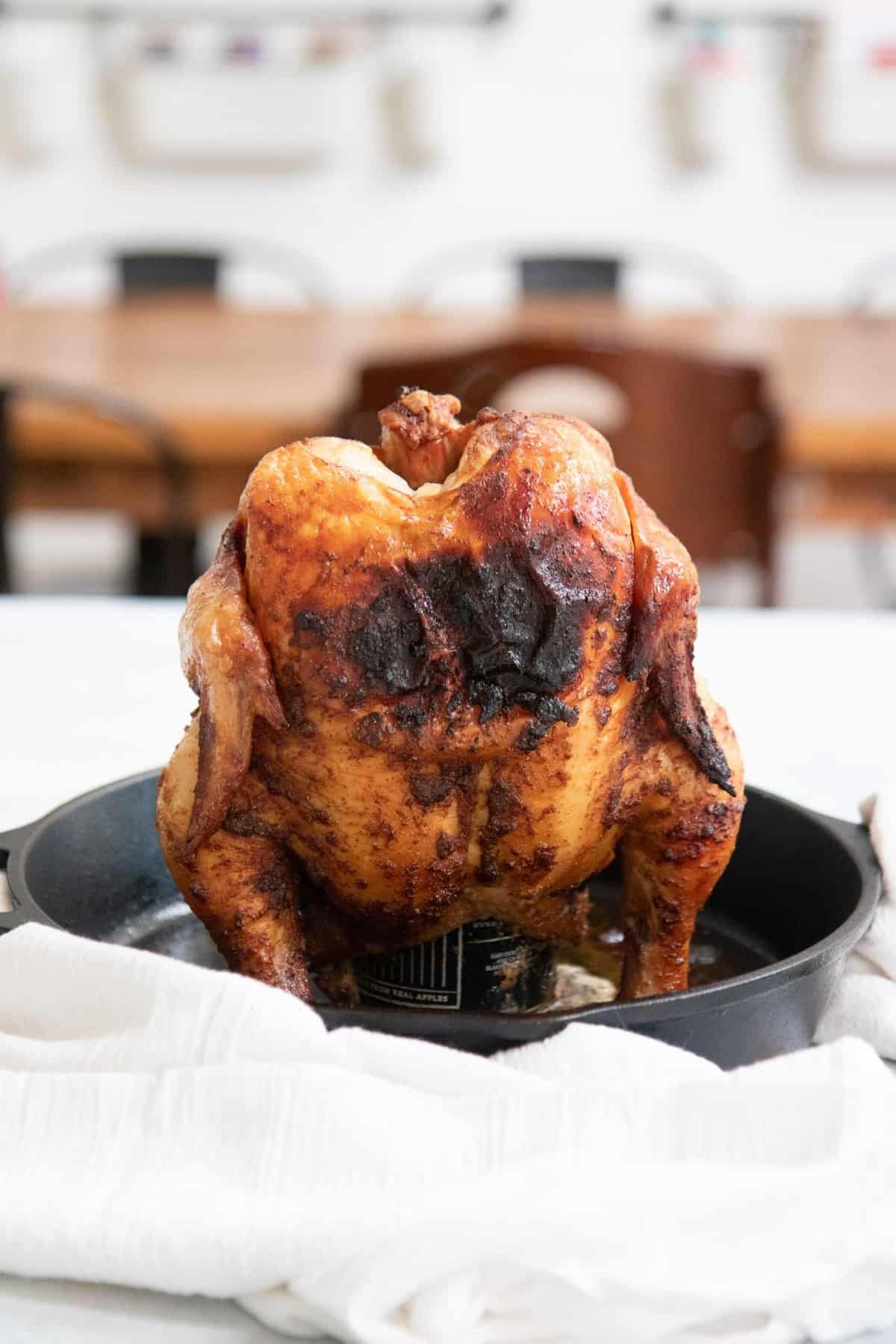 Grilled Beer Can Chicken standing up in a cast iron skillet