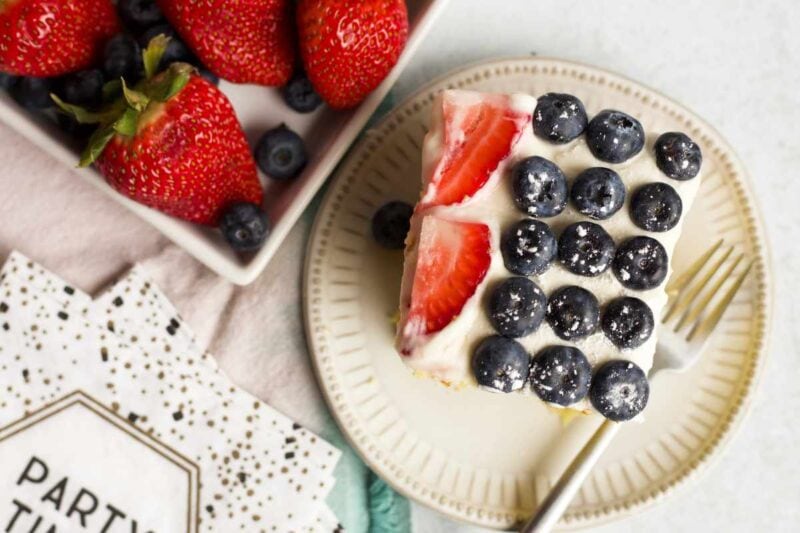 Tight view of the top of a slice of cake decorated with berries.