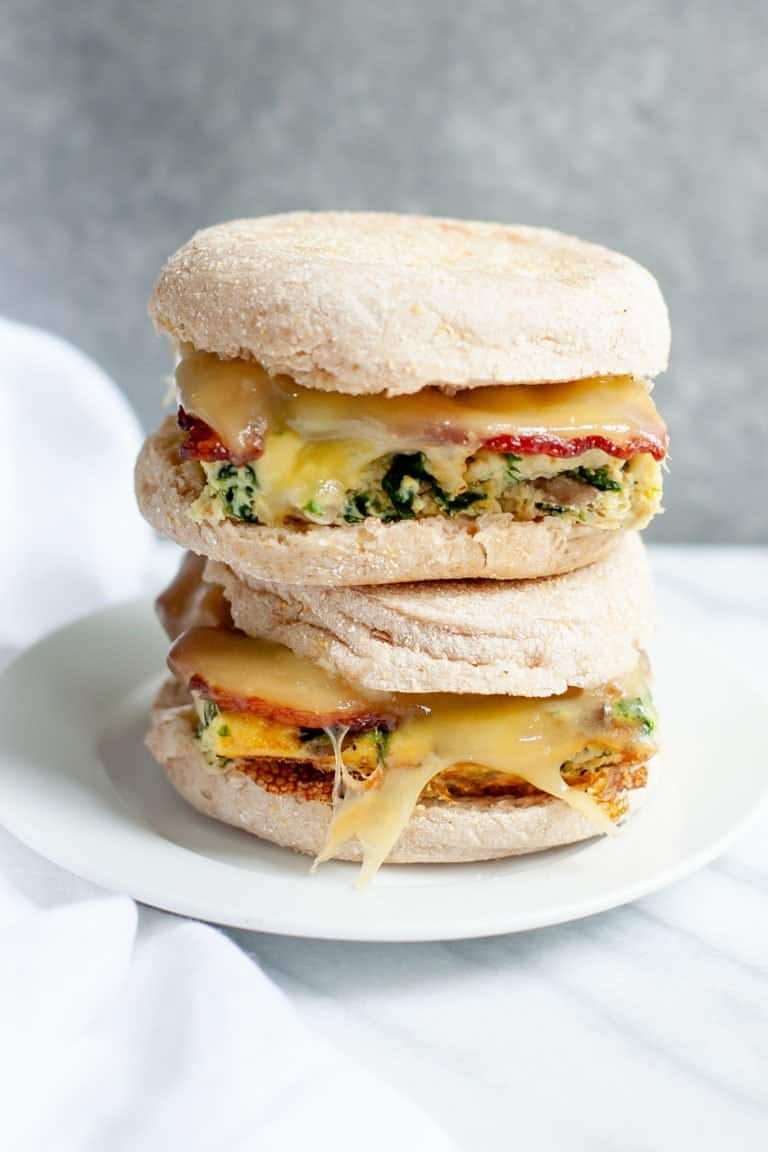 Side shot of two Meal Prep Breakfast Sandwiches, stacked on top of each other on a white plate