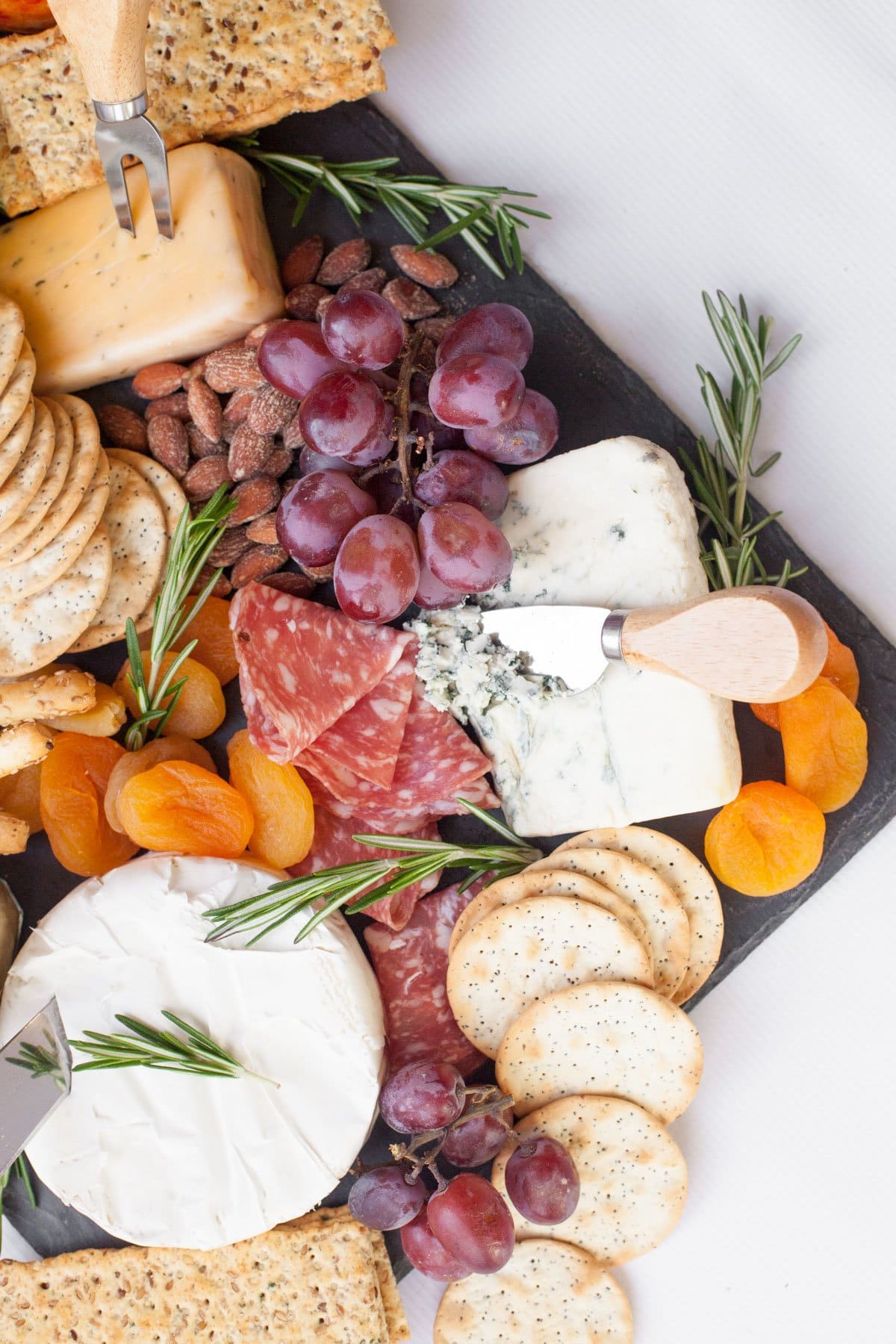 Close up of a full cheese board on a slate platter