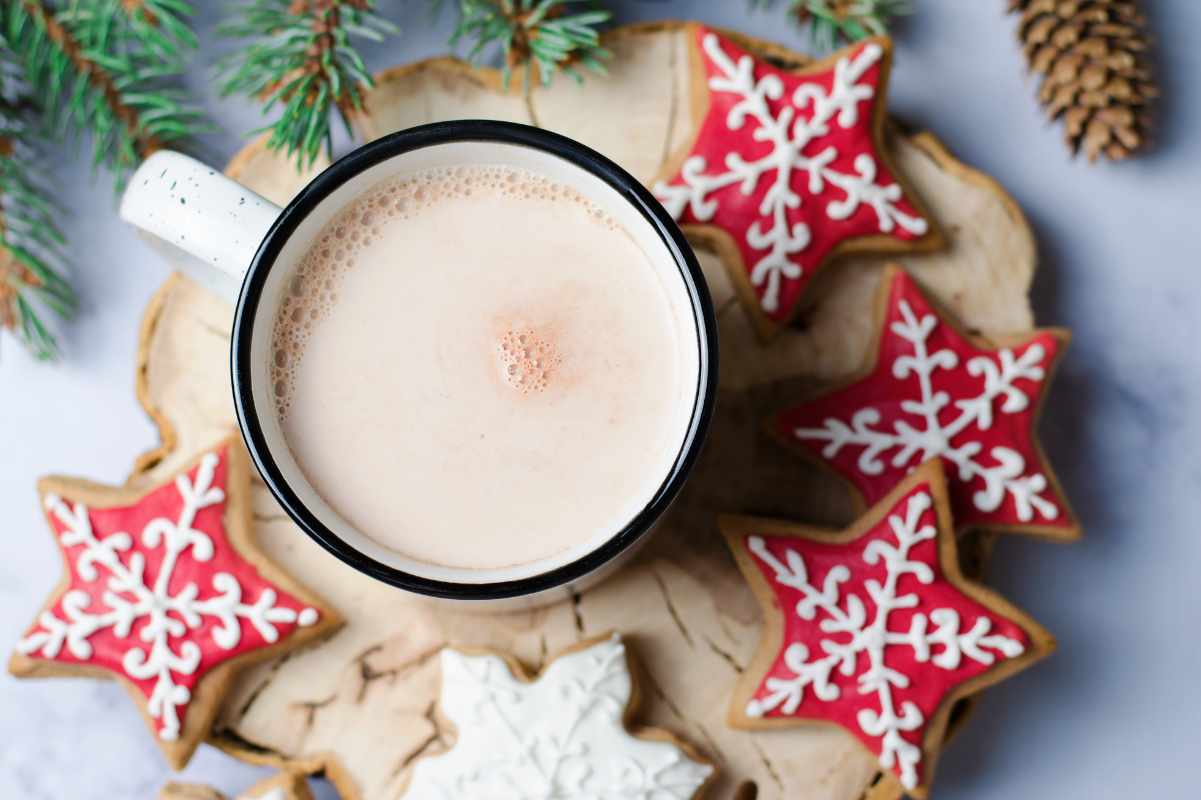 Mug of cocoa surrounded by sugar cookies