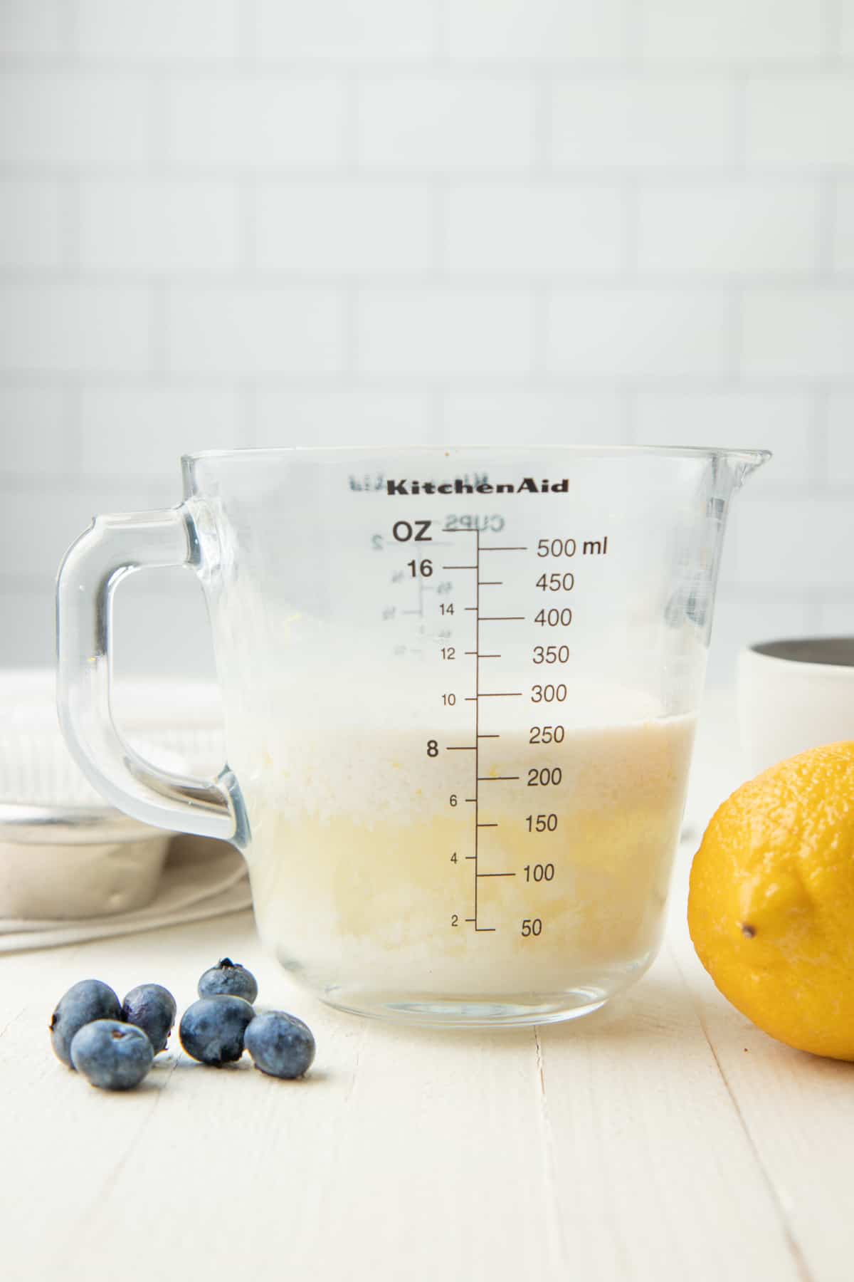 Curdled plant-based milk sits in a glass measuring cup.