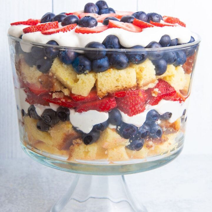 Closer view of a festive berry trifle in a trifle dish on a light background.