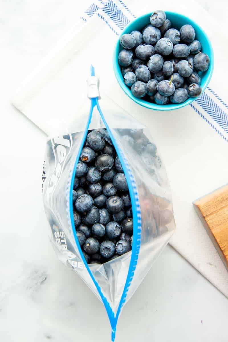 Overhead of individually frozen blueberries in an open freezer bag.