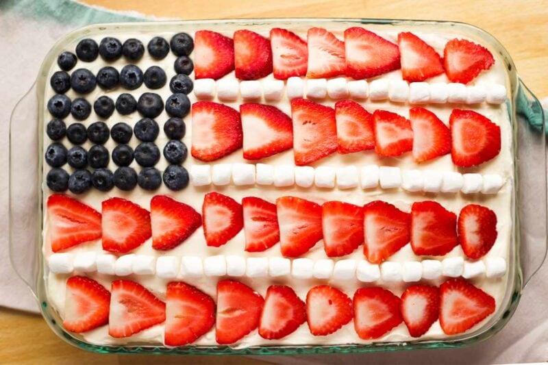 Overhead of a fully assembled flag cake with strawberry and marshmallow stripes and blueberry stars.