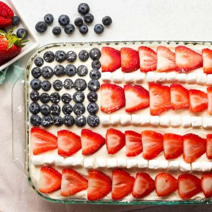 Forks rest alongside a glass baking dish with a cake decorated to look like the American flag.