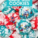 Overhead of red, white, and blue cookies served on a white platter with festive decorations around. A text overlay reads, "4th of July Cake Mix Cookies."