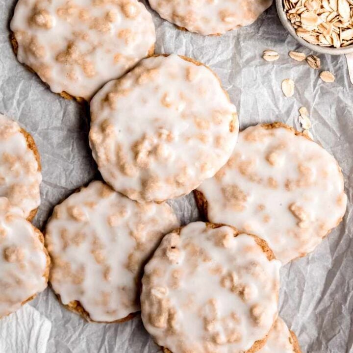 Frosted cookies served on a parchment paper lined tray.