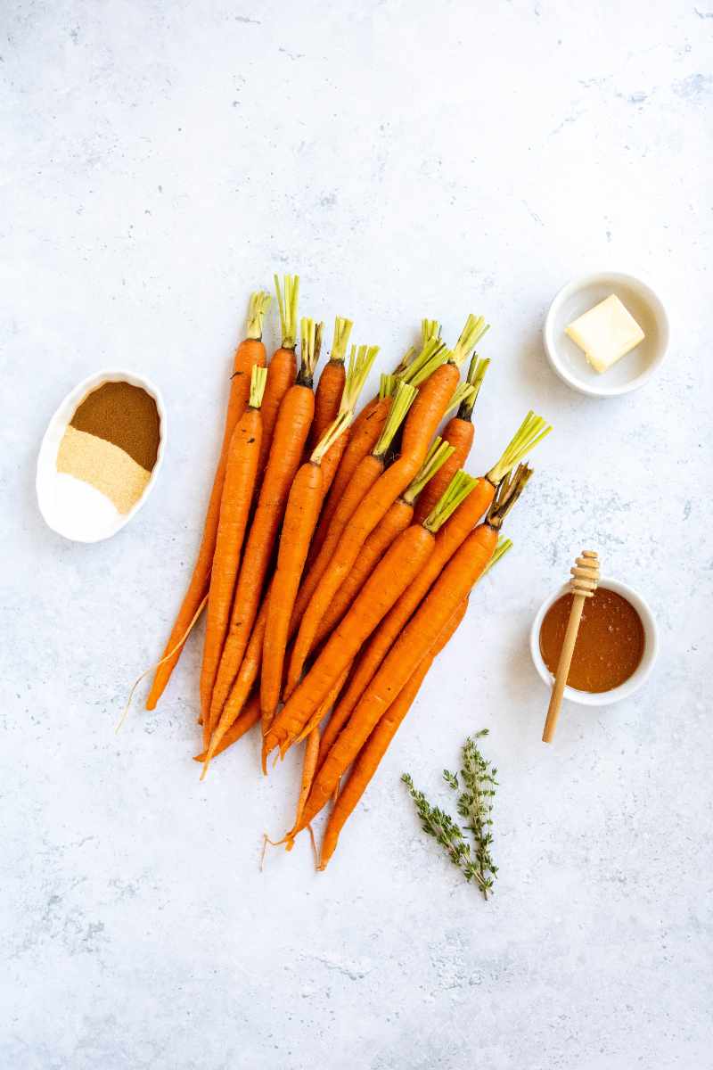 Overhead of all ingredients needed to make honey glazed carrots.