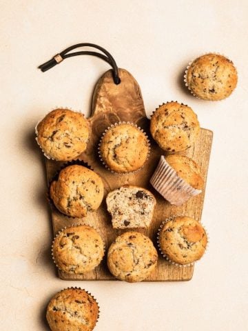 Overhead of gluten-free banana muffins on a wooden cutting serving board.