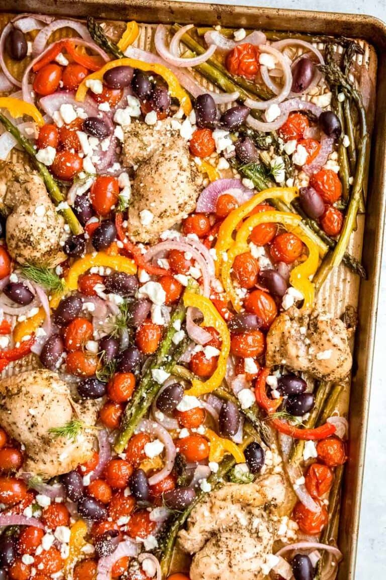 Overhead of greek chicken dinner tray bake with veggies and feta cheese.