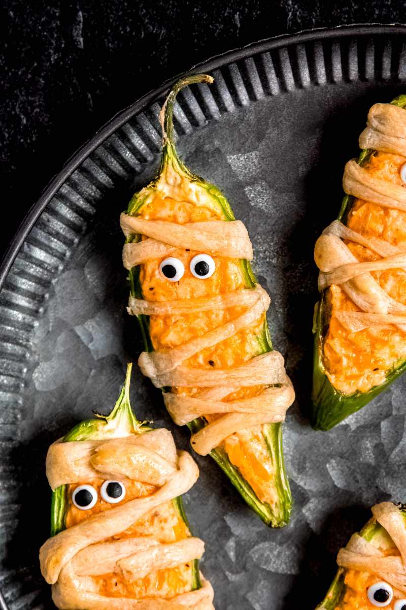 Easy Halloween appetizers served on a dark round tray.