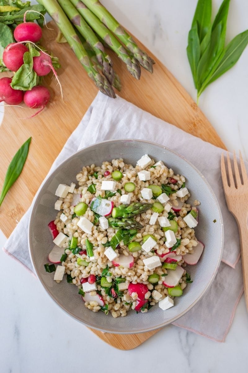 Overhead of grain salad with radish, asparagus, and cooked barley.