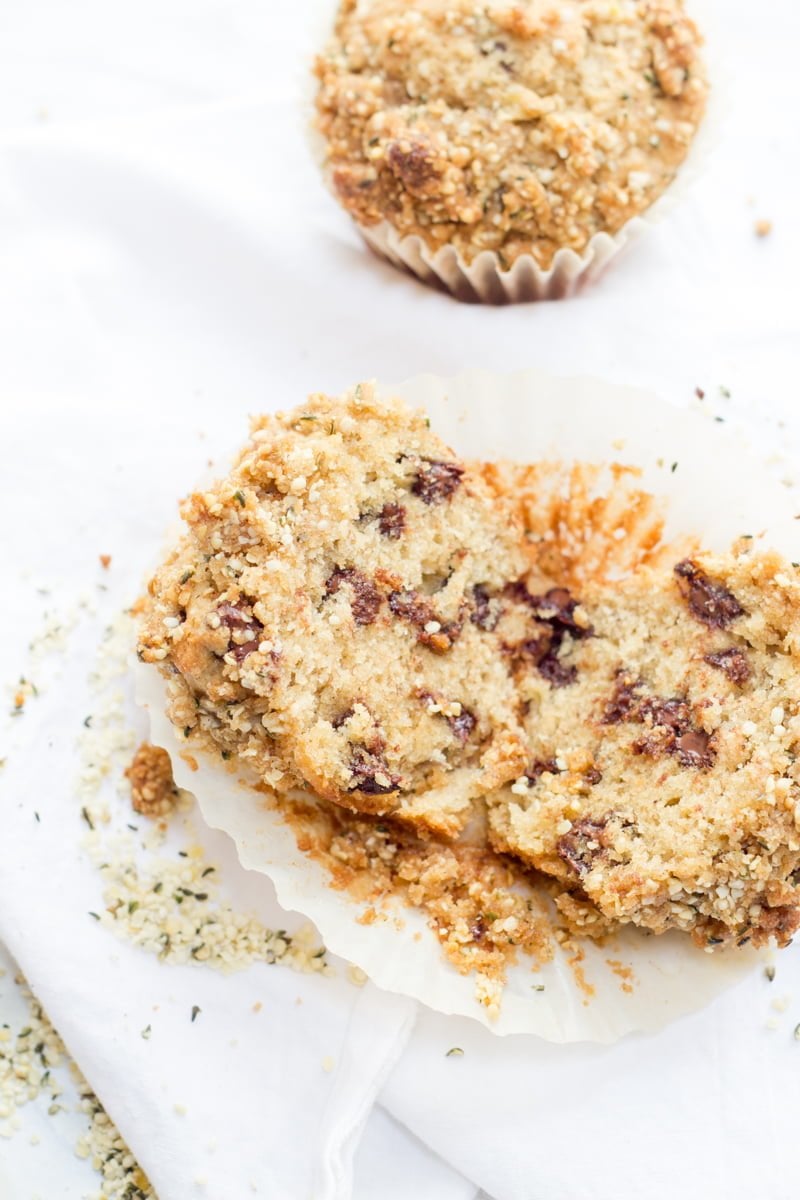 A muffin split apart sits by itself in a wrapper.