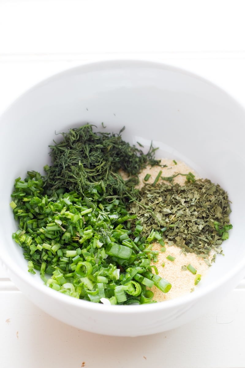 Spices and herbs for homemade ranch dressing in a white bowl