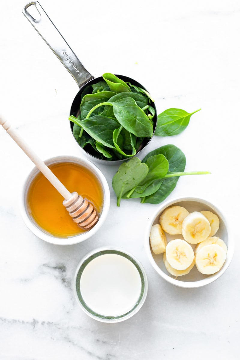 Overhead of all the ingredients needed to make a creamy spinach smoothie.