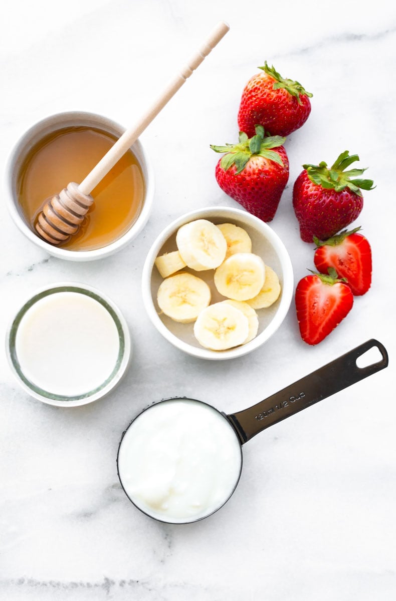 Overhead of five ingredients needed to make a simple fruit smoothie.