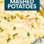 Tight view of a wooden spoon scooping mashed potatoes from a large serving bowl. A text overlay reads, "Instant Pot Mashed Potatoes. Easy & Creamy."