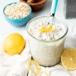 A jar is filled with lemon poppyseed overnight oats. It is topped with a twirl of lemon zest.