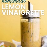 Close up of homemade lemon vinaigrette in a glass bottle for pouring. A text overlay reads, "Easy. Healthy. Cheap. Homemade Lemon Vinaigrette."