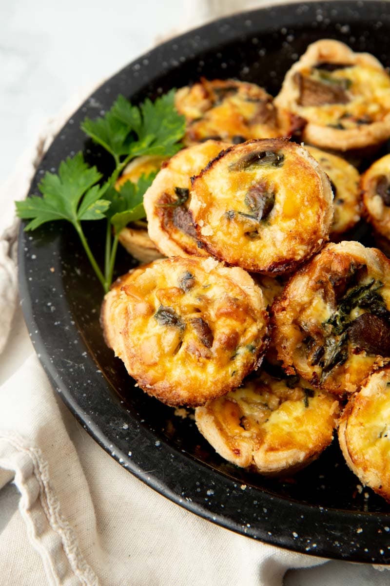 Christmas appetizers stacked on a plate with a parsley sprig.