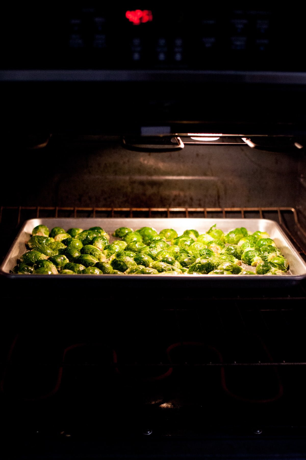 A tray of vegetables roasts in the oven