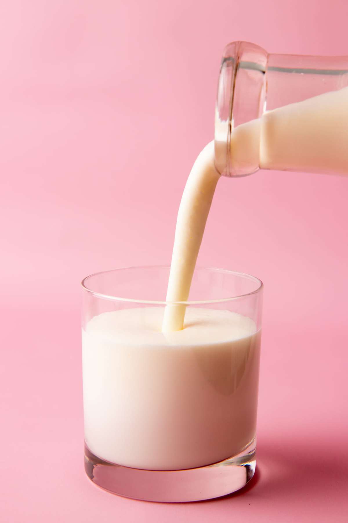 Close-up of pouring homemade kefir into a glass tumbler.