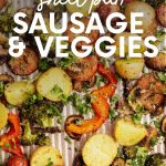 Tight view of roasted vegetables and slices of sausage on a ridged baking sheet. A text overlay reads, "Sheet Pan Sausage & Veggies."