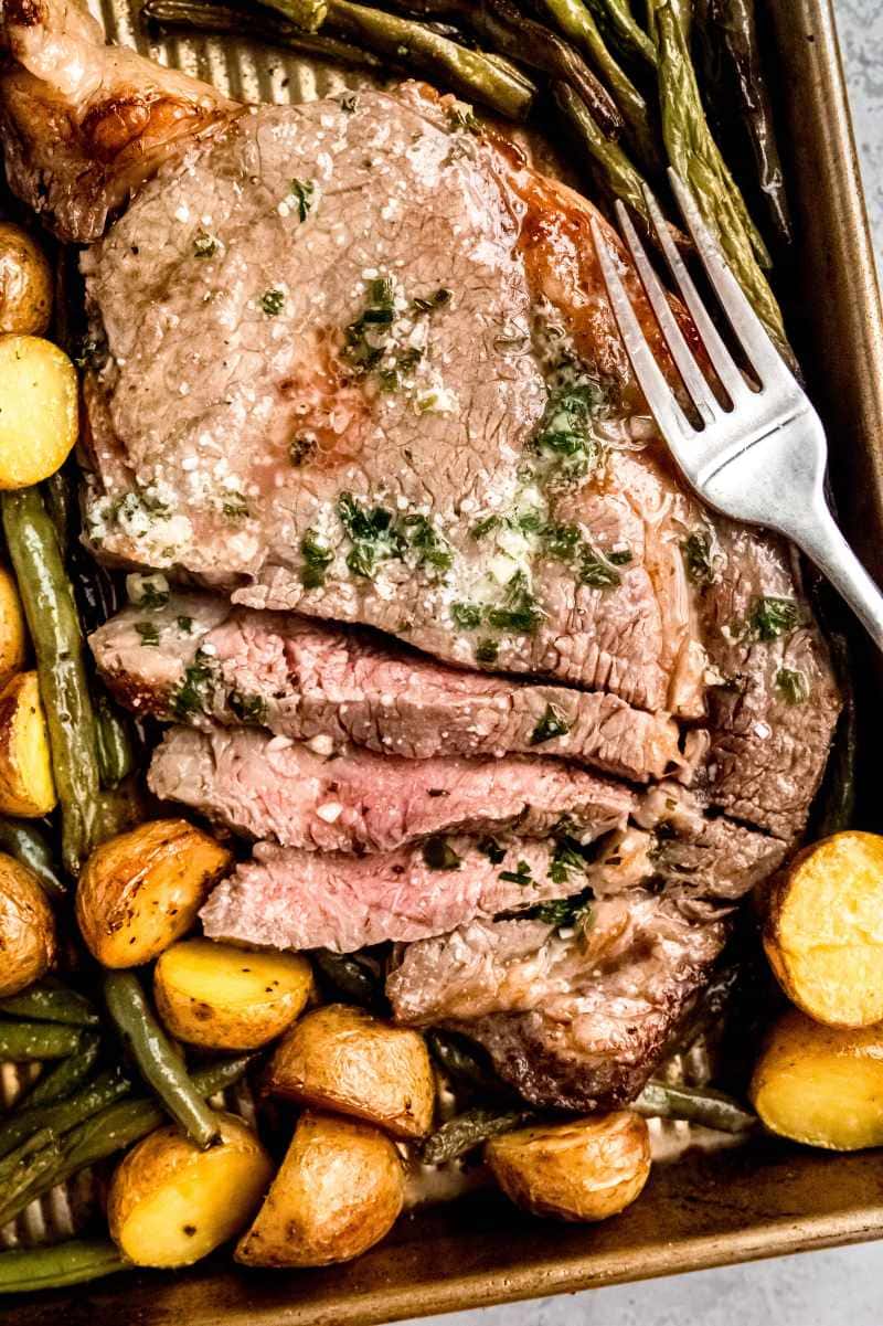 Overhead of a steak sheet pan dinner with veggies and a fork.