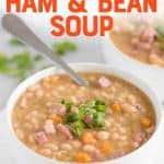 Cooked ham and beans in a white bowl with a spoon and scallion garnish. A text overlay reads "Slow Cooker Ham and Bean Soup."