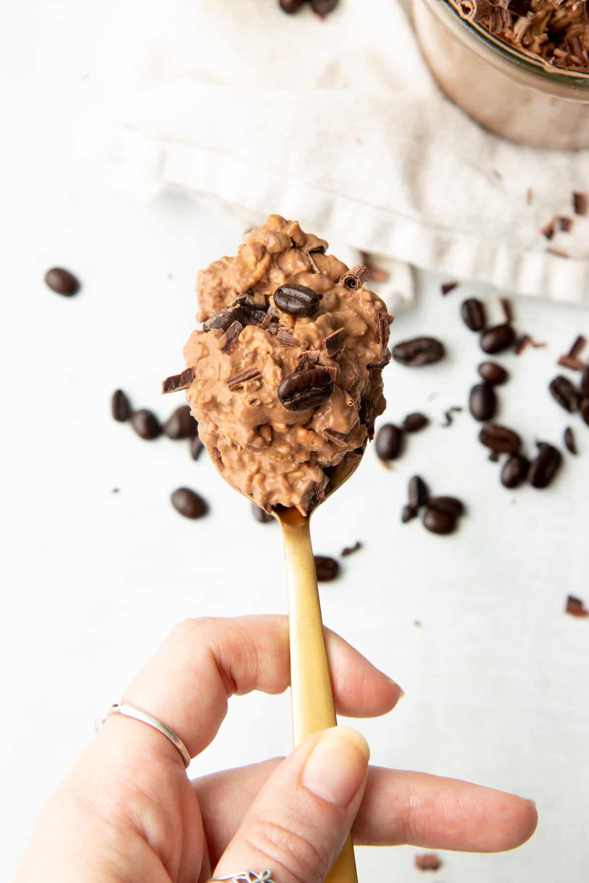 A spoon holds a bite of chocolate coffee overnight oats.