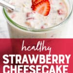 A glass jar filled with strawberry cheesecake overnight oats sits on a marble countertop. The oats are garnished with strawberry slices, and a spoon dips into the jar. A text overlay reads "Healthy Strawberry Cheesecake Overnight Oats."