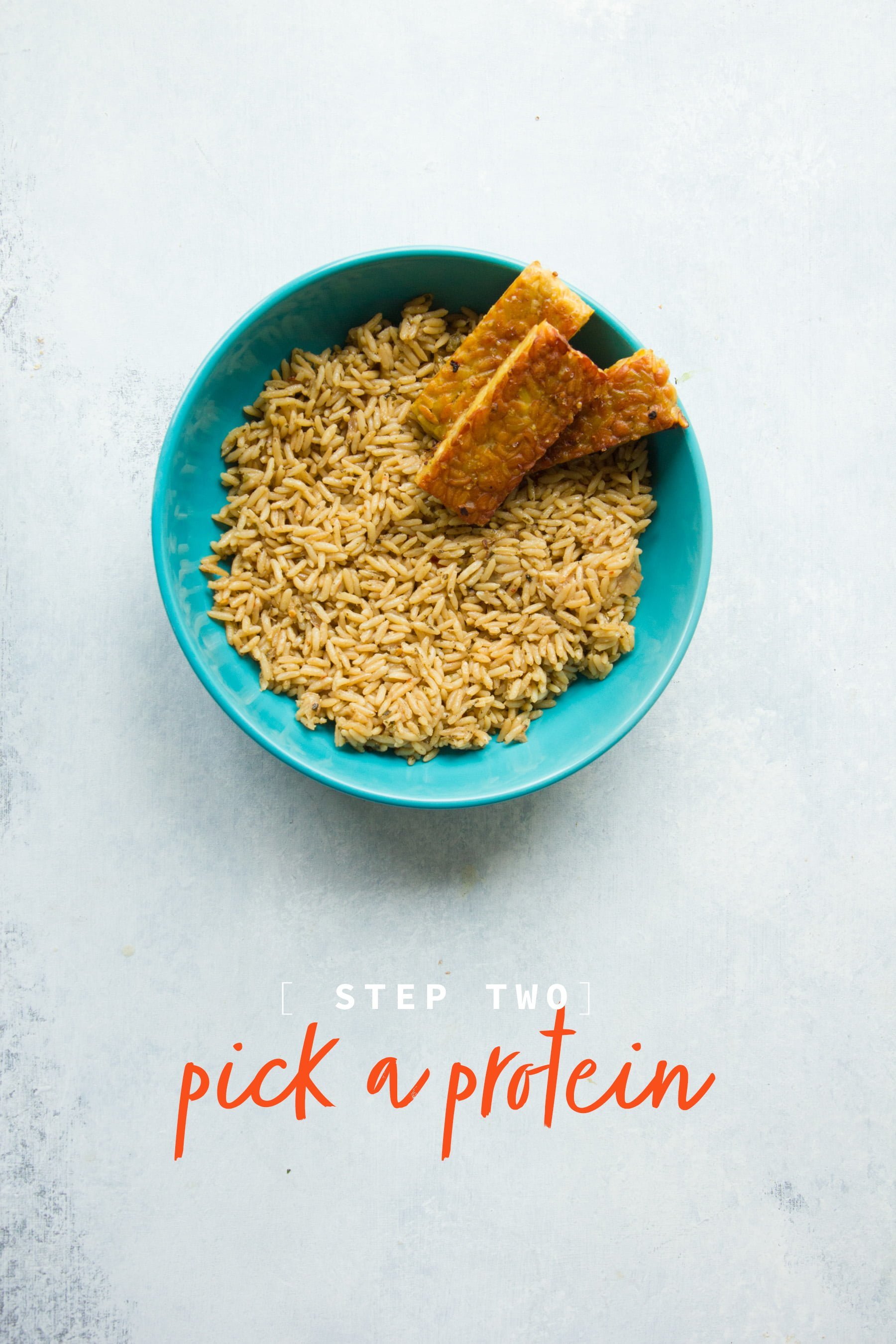 A teal bowl filled with brown rice and tofu. A text overlay reads "Step 2: Pick a protein"