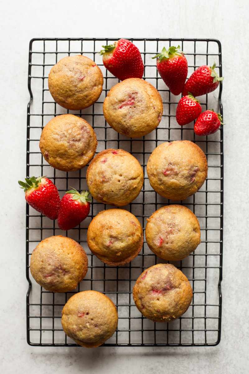 Strawberry muffins cool on a wire rack.