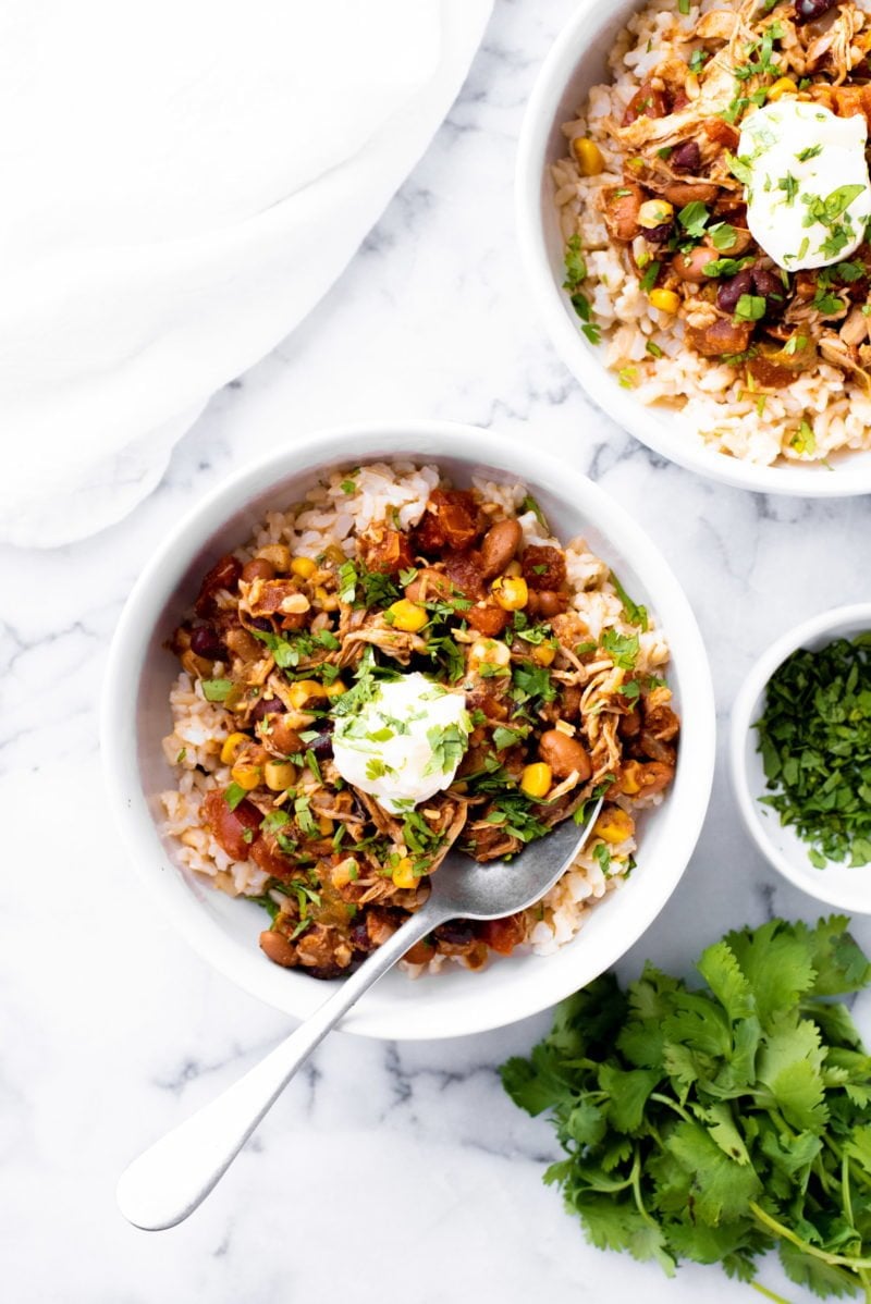 Overhead shot of Slow Cooker Summer Chicken Chili in a white bowl with a metal spoon