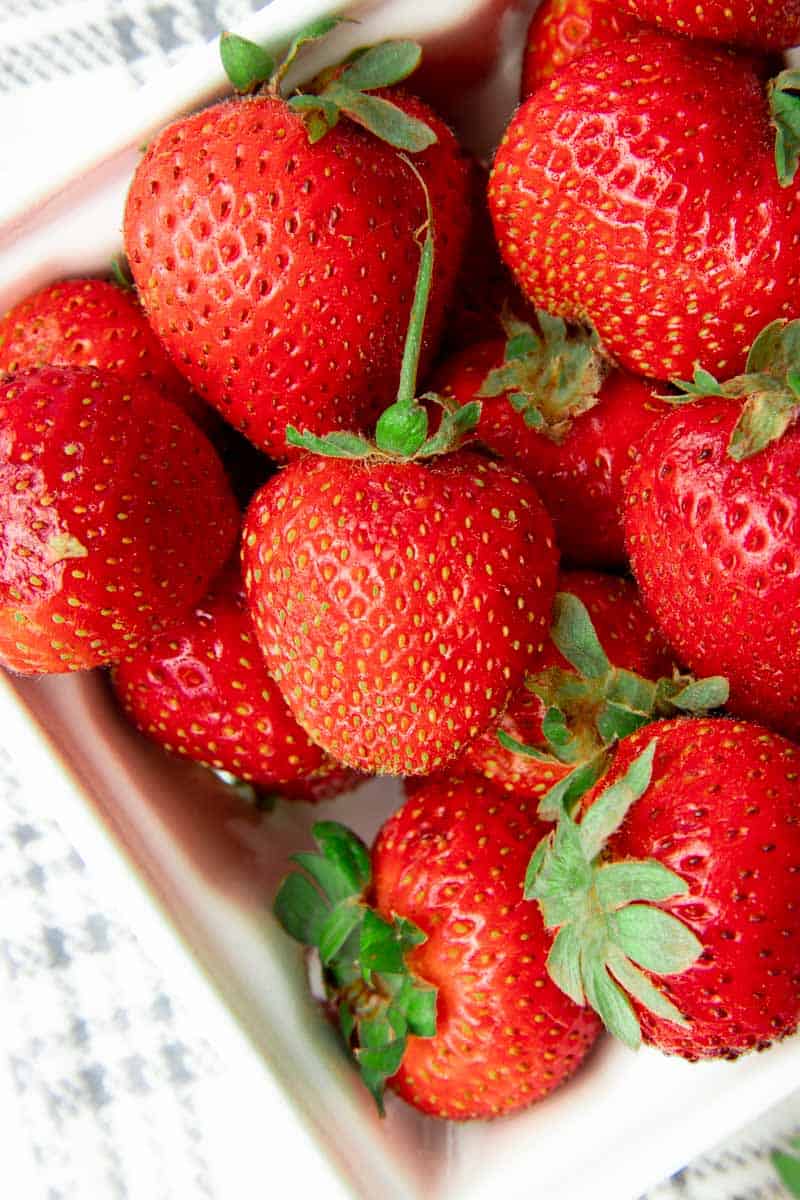 Close view of fresh berries in a ceramic punnet.