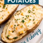 Twice baked potatoes served on a white platter topped with snipped chives. A text overlay reads, "Twice Baked Potatoes. Easy & Cheesy."