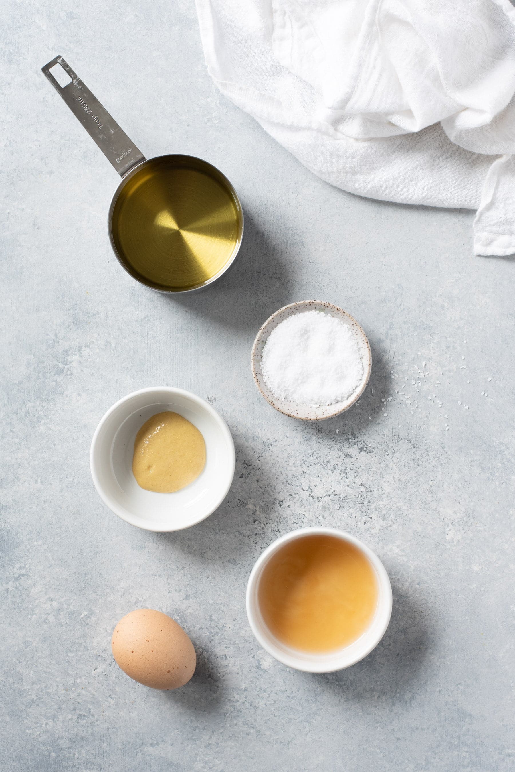 Overhead shot of ingredients for Homemade Mayo - oil, egg, vinegar, mustard, salt