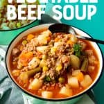 Two teal bowls of vegetable beef soup sit on a tea towel. A text overlay reads "Use Your Pantry Staples! Vegetable Beef Soup"