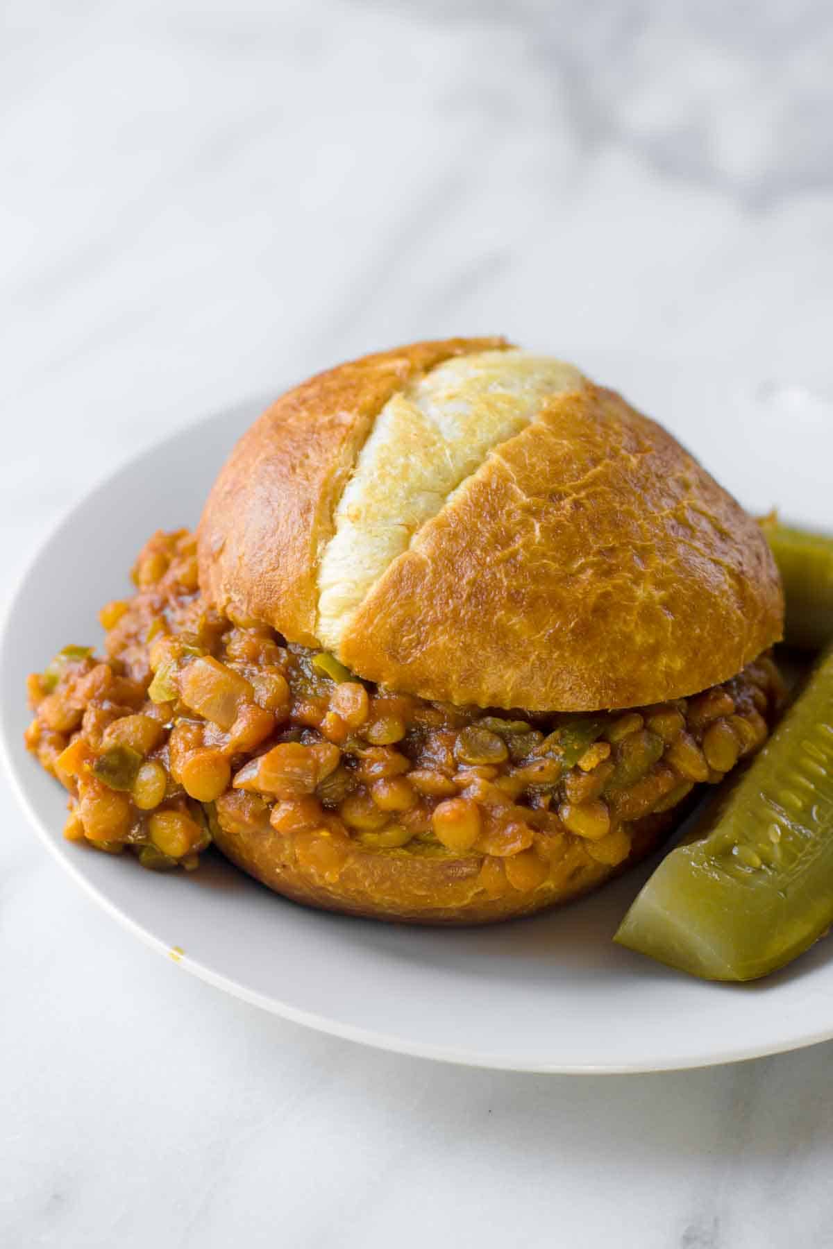 A finished lentil sloppy joe sits on a plate.