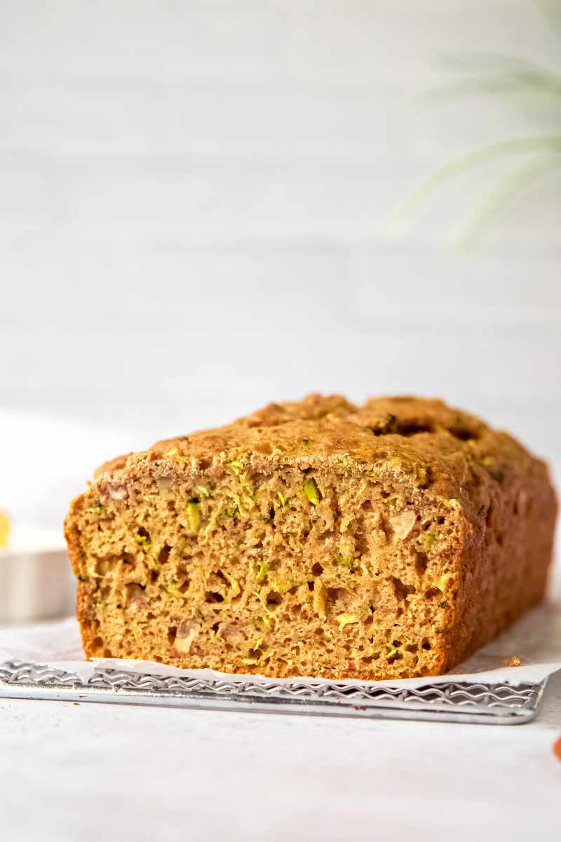 Tight view of the cut side of a loaf of whole wheat quick bread showing the tender, moist crumb.