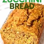 Close view of a loaf of whole wheat zucchini bread with slices cut for serving, showing the tender middle. A text overlay reads, "Whole Wheat Zucchini Bread."